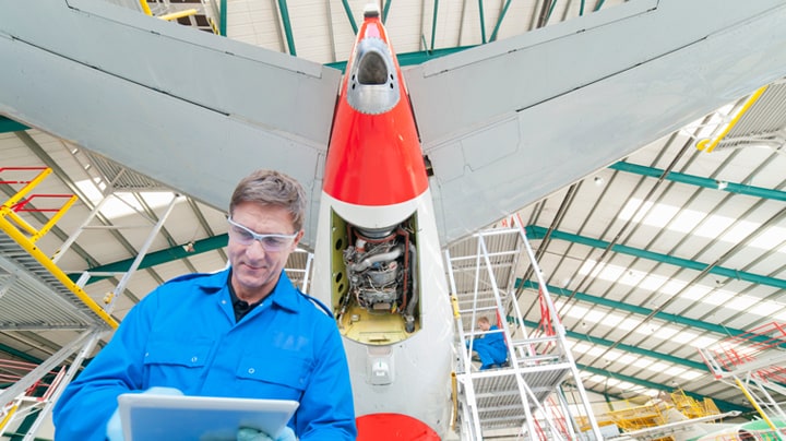 Ein Mann arbeitet am Heckteil eines Flugzeugs.