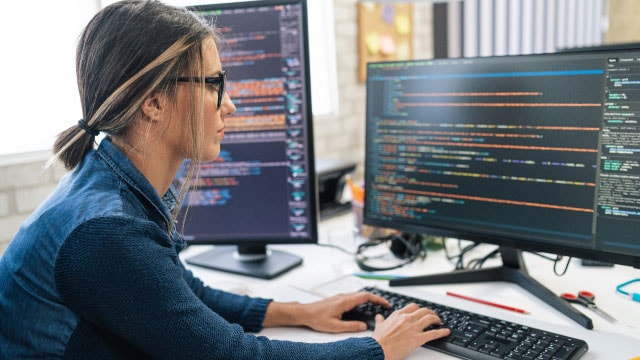 eine Person, die einen Code auf einem Monitor betrachtet