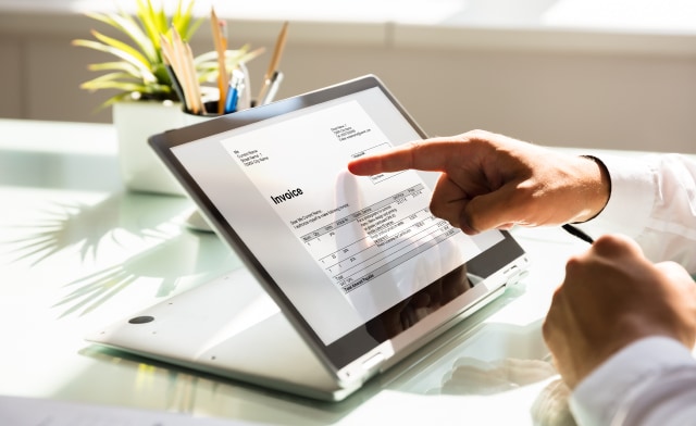 Person, die eine Rechnung auf einem Tablet betrachtet