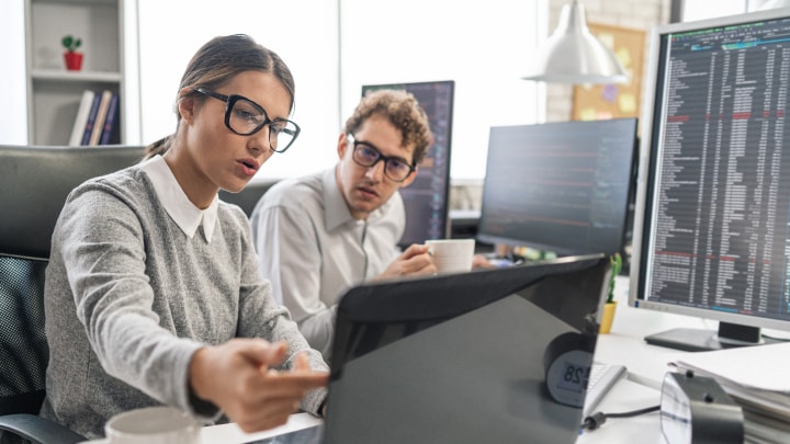 Zwei Personen schauen auf einen Monitor