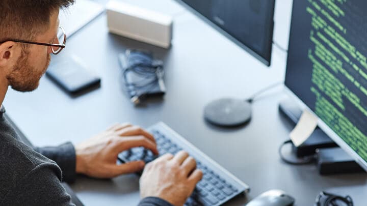 Person, die vor einem Computer auf einer Tastatur tippt