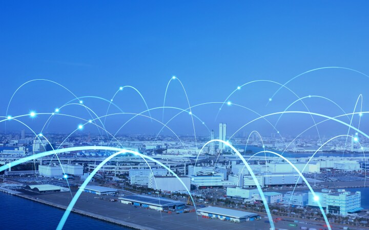 Stadtbild mit leuchtenden geschwungenen Linien, die die digitale Konnektivität darstellen