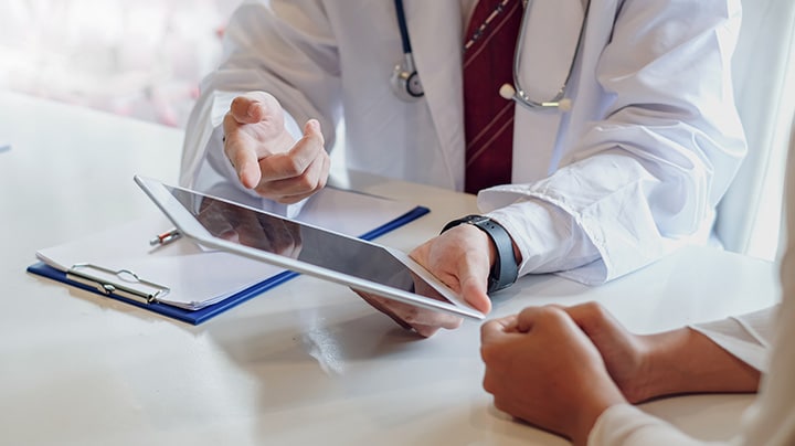A doctor showing medical reports on a tablet
