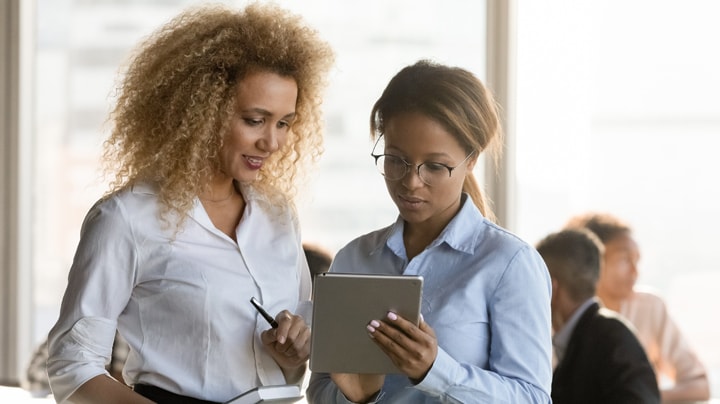 Two people looking at a tablet 