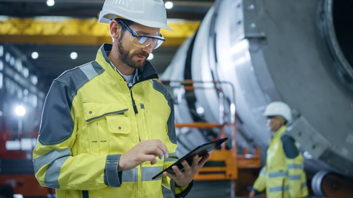 A person looking at a tablet in a manufacturing facility 