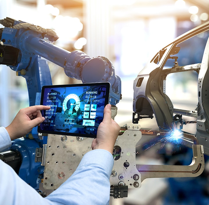 A person holding tablet infront of automotive machines
